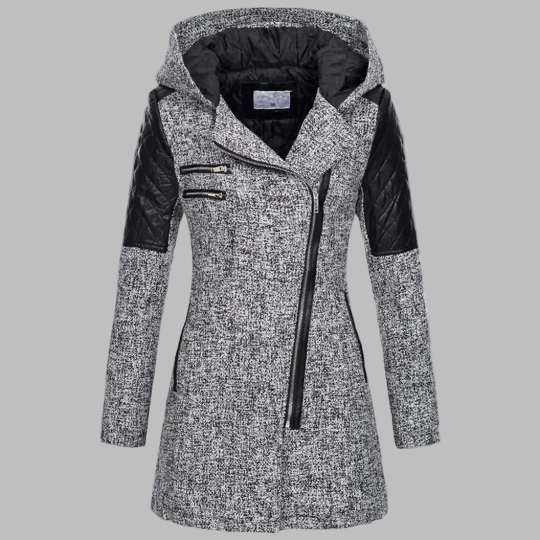 Grijze dames winterjas met capuchon, asymmetrische ritssluiting en zwarte leren accenten, ideaal voor koude weersomstandigheden en modieuze winterstijl.